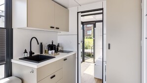 Une cuisine moderne équipée d’un évier, de placards et d’un plan de travail.
