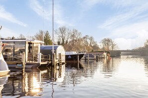A marina with boats docked, a covered structure, and a calm water body.
