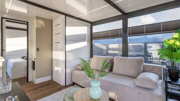 A modern interior with a sofa, a dining table, and a plant.