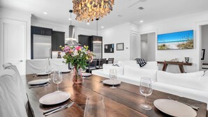 A modern kitchen with dark cabinets, a white countertop, and a hanging light fixture. - 🦩Book Me Baby! Sun Of A Beach in Santa Rosa Beach~Golf Cart Included🦩 (Santa Rosa Beach)