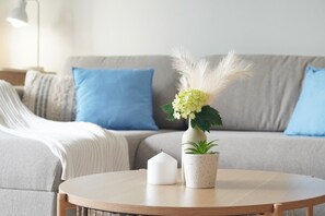 A round wooden table with a white candle and a white pot with green plants. - Stylish Sydney 2BR UNSW, Beach, Parking, Sleeps 6 (Kingsford)