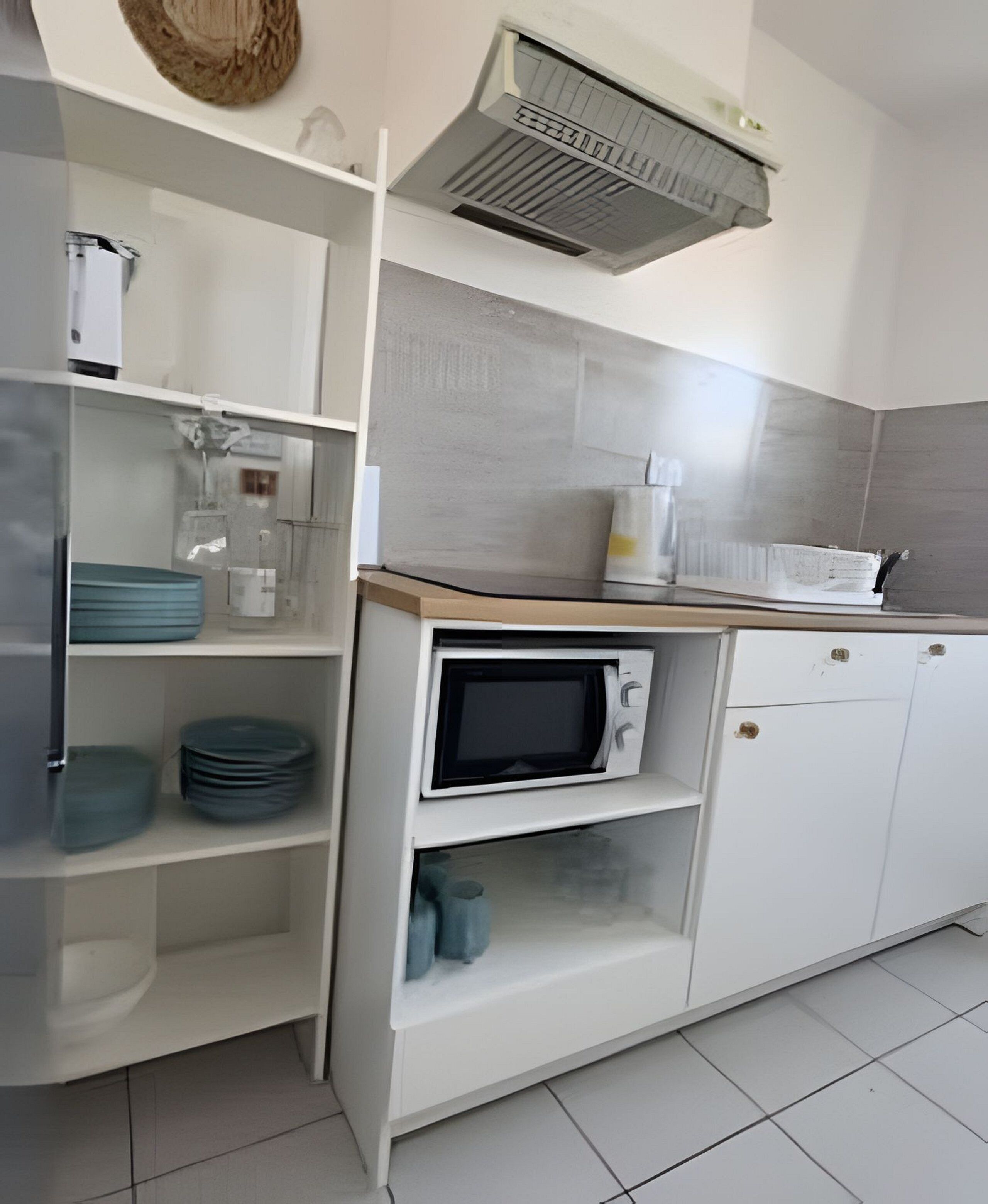 A kitchen with white cabinets, a microwave, and a sink.