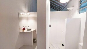 A bathroom with a white toilet, a sink, and a mirror. - Mio Trancoso (Porto Seguro)