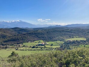 A rural landscape with a house surrounded by fields and distant mountains. - The Encantade Guesthouse (TREVILLACH)
