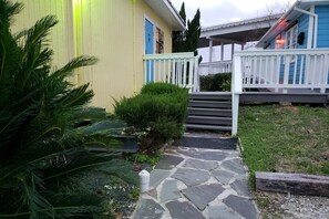 Un sentiero conduce a una casa con un portico bianco e una porta blu.