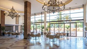 Un vestíbulo espacioso con techos altos, ventanas amplias y un gran candelabro.