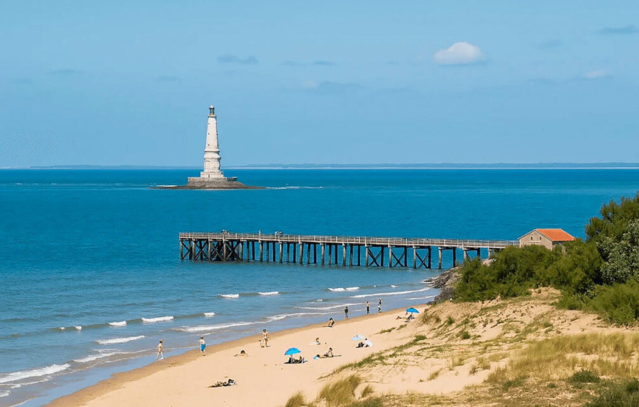 A coastal scene with a lighthouse, pier, beach, and a building on the shore.