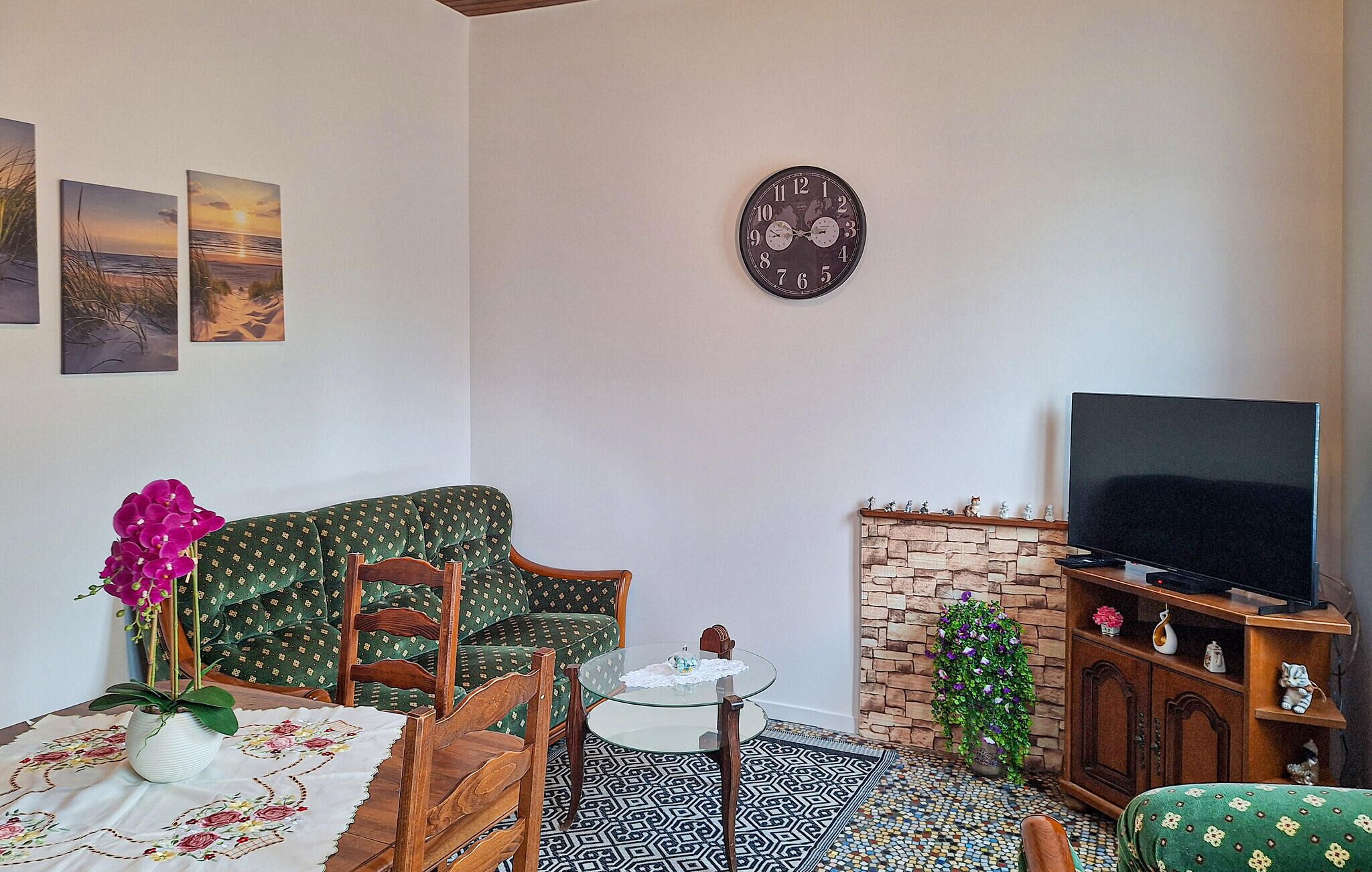 Un salon avec un canapé, une table en verre, un téléviseur et une cheminée.