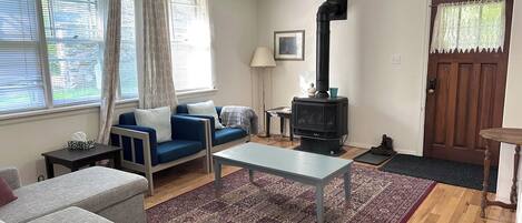 Un salon avec un canapé, une table, une cheminée et une porte.