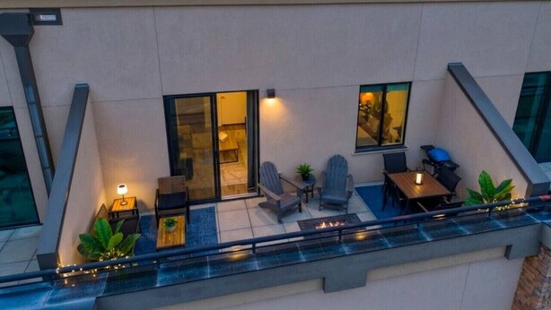 Una terrazza panoramica sul tetto con piscina, zona relax e vista sulle montagne.