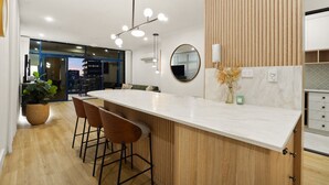 Una cucina moderna con un piano di lavoro in marmo, elementi in legno e un grande specchio.