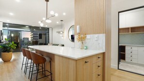 Una cucina moderna con un'isola in legno, sgabelli da bar e un'ampia finestra.