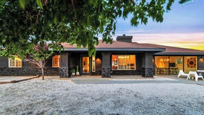 A modern building with a stone facade, large windows, and a gravel driveway.