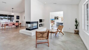 A spacious living area with a fireplace, modern furniture, and a view of the outdoors.