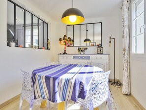 Ein Schlafzimmer mit einem Bett, einer Kommode, einem Spiegel und einem Fenster mit Vorhängen.
