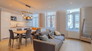 Eine moderne Wohnung mit Essbereich, Sofa und Küche.