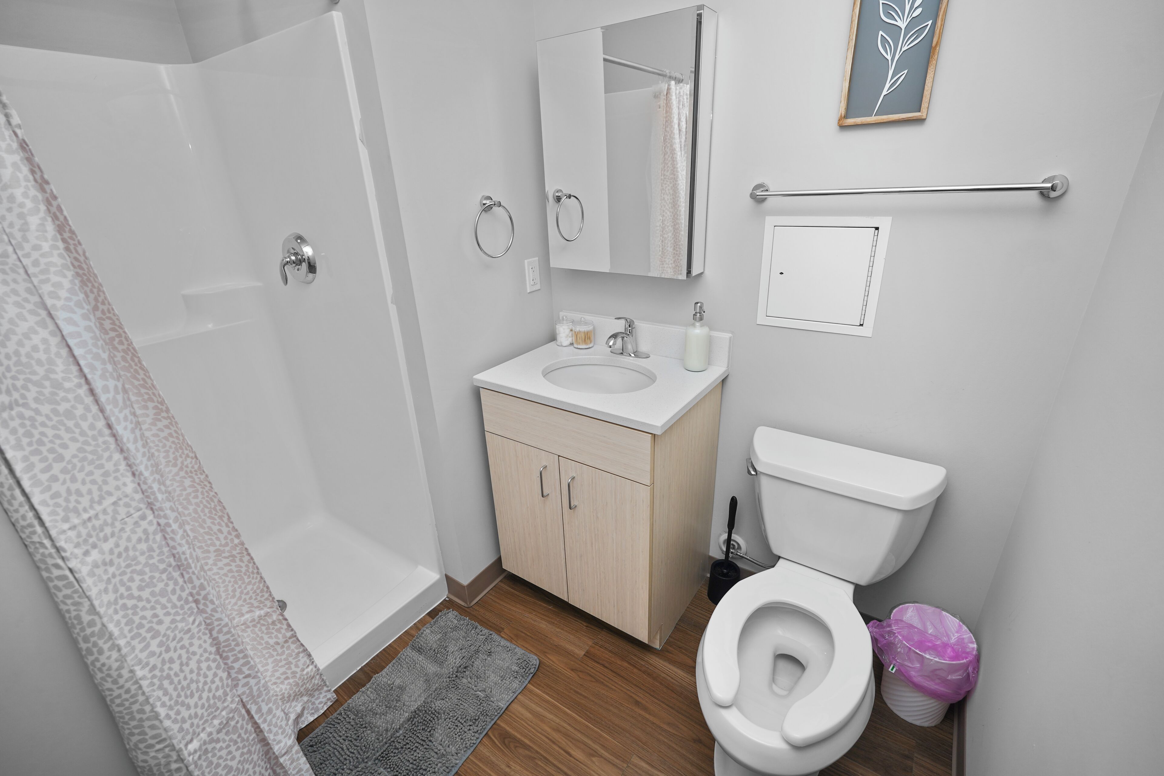Un baño moderno con ducha, inodoro, lavabo y espejo.