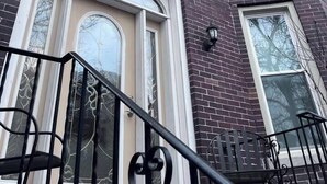A multi-story brick building with a prominent front door, large windows, and a black metal railing. - Chicago Gem: Wrigley - Lakefront - Red Line Train (Chicago)