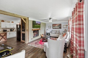 Ein Wohnzimmer mit Kamin, einer Couch, einem Couchtisch und einem Fernseher.