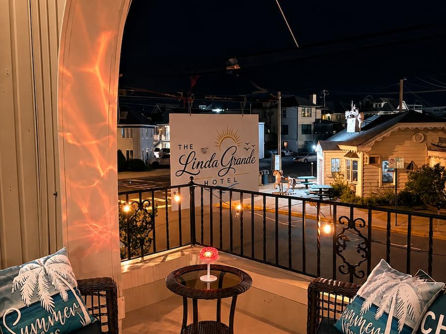 A balcony with wicker furniture and a sign for 'The Linda Grande Hotel.'
