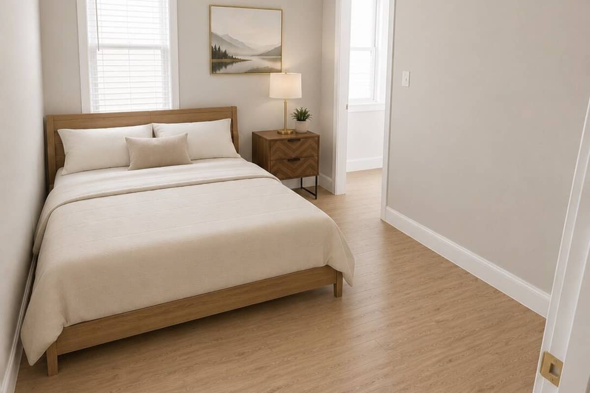 Une chambre à coucher avec un lit, une table de chevet, une lampe et un tableau au mur.