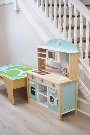 Un juego de cocina infantil frente a una escalera.