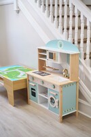 Un juego de cocina infantil frente a una escalera.