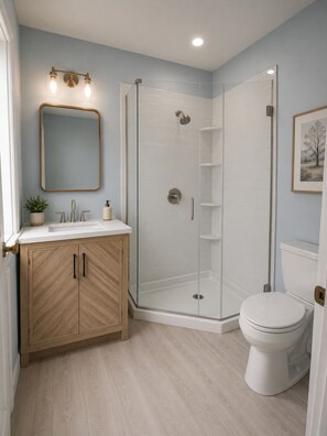 A bathroom with a shower, toilet, sink, and mirror. - The Linda Grande Hotel (Ocean City)