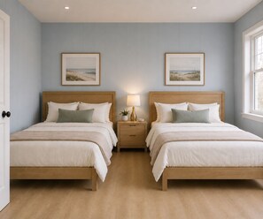 A bedroom with two beds, a nightstand with a lamp, and two framed pictures on the wall. - The Linda Grande Hotel (Ocean City)
