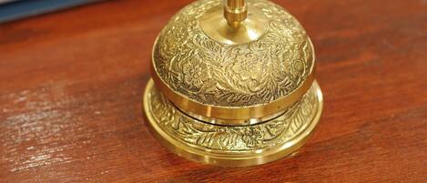 A brass object with intricate designs on a wooden surface.
