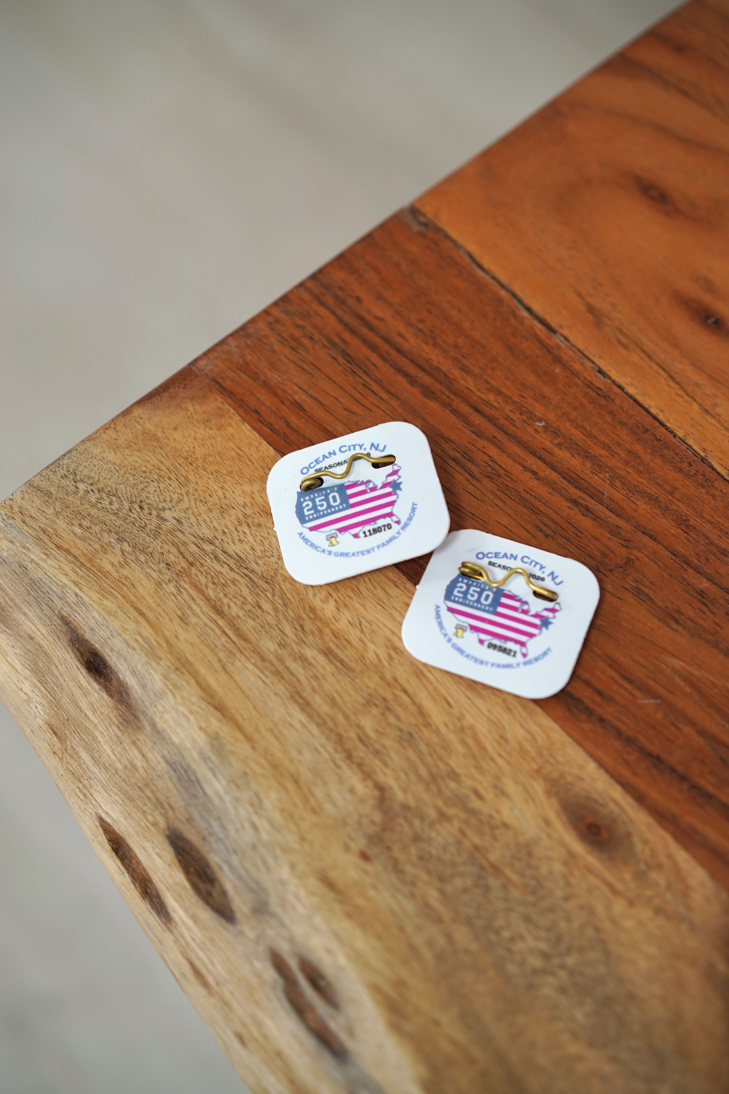 Two white tags with text and a map on a wooden table.
