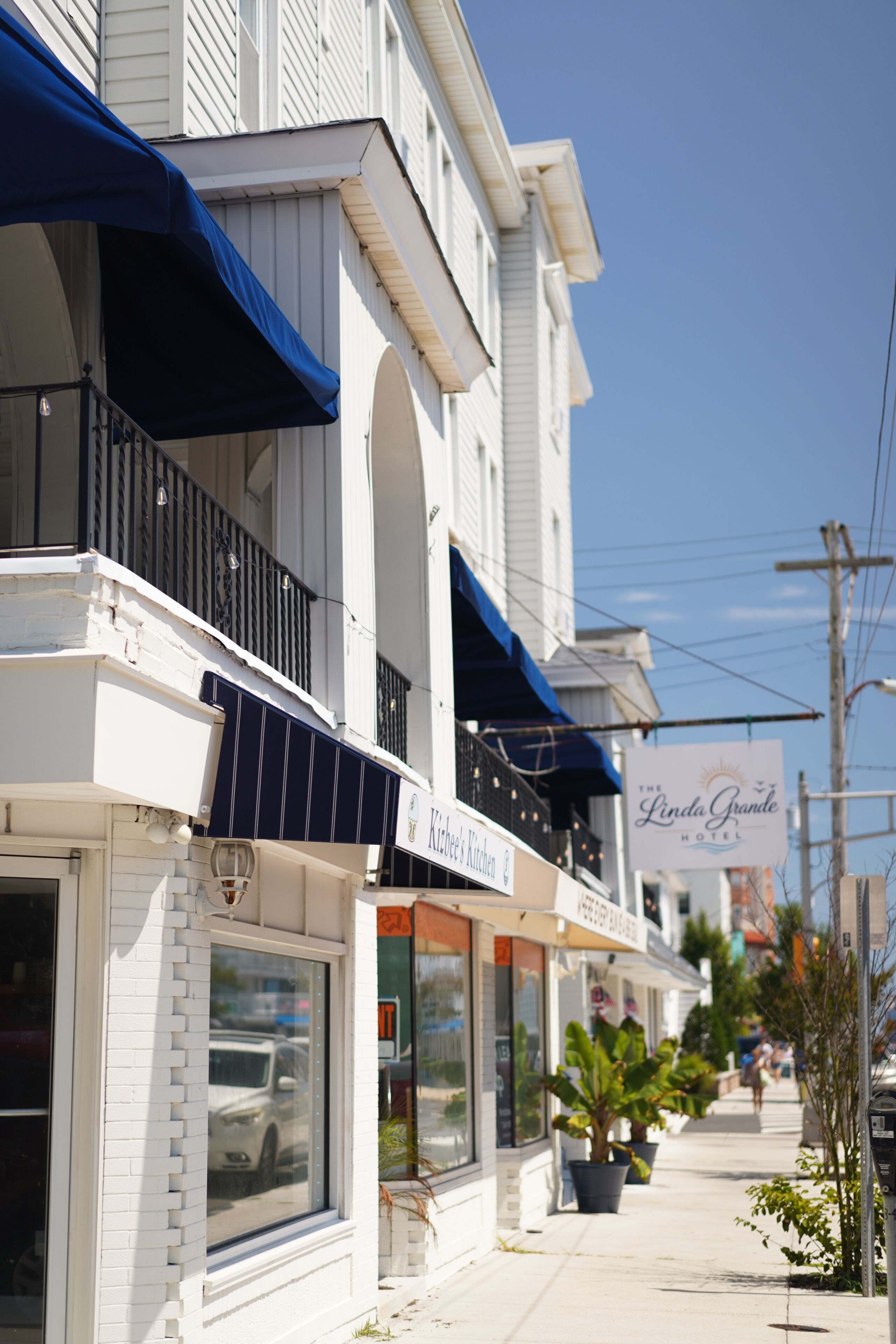 A row of buildings with storefronts, including a visible sign for 'The Linda Grande Hotel'.