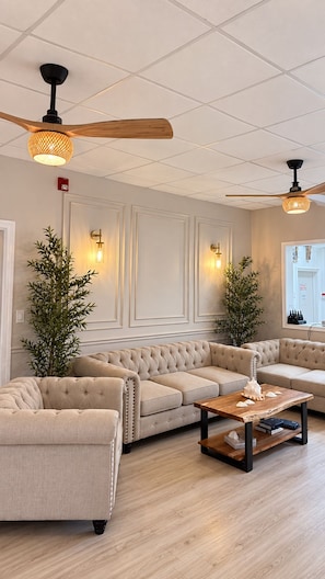 A modern living room with a sectional sofa, a wooden coffee table, and two floor lamps.