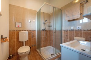 A bathroom with a toilet, a shower with a glass door, and a sink. - Villa Natalie (Istria - Rakalj) (Rakalj)