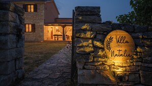 A stone wall with a wooden sign reading "Villa Natalie" illuminated by warm lighting. - Villa Natalie (Istria - Rakalj) (Rakalj)