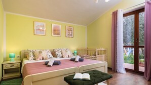 A bedroom with a bed, bedside tables, a window with curtains, and a view of the outdoors. - Villa Natalie (Istria - Rakalj) (Rakalj)