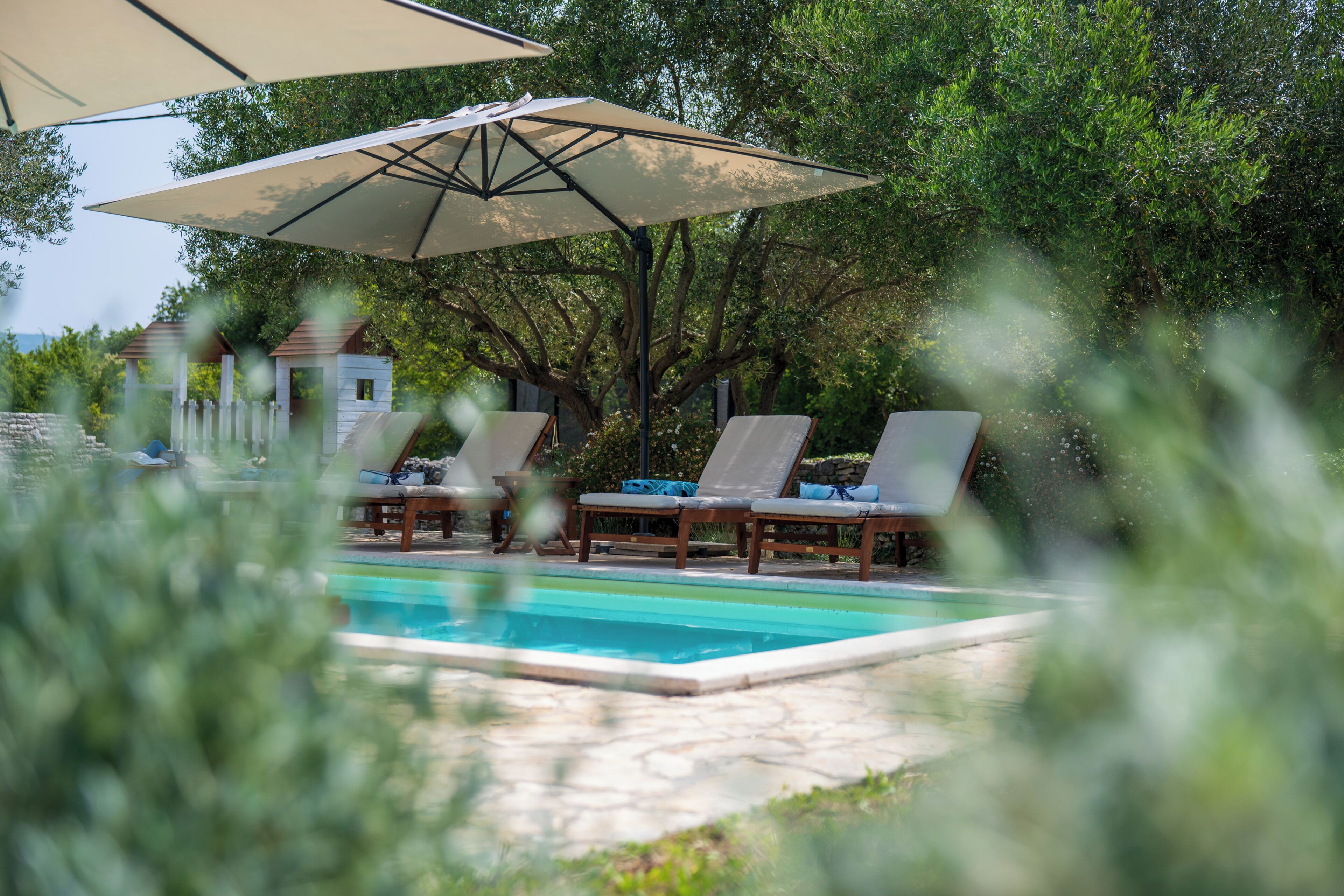 A pool area with lounge chairs and umbrellas.