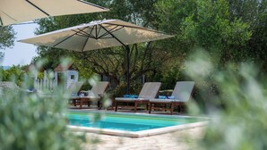 A pool area with lounge chairs and umbrellas. - Villa Natalie (Istria - Rakalj) (Rakalj)
