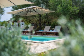 A pool area with lounge chairs and umbrellas. - Villa Natalie (Istria - Rakalj) (Rakalj)