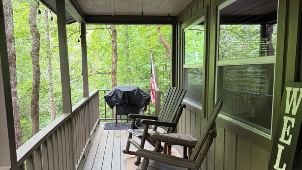 A porch with two rocking chairs, a ceiling fan, and a 'WELCOME' sign. - Cozy cabin, whispering creek, and fire pit (Hiawassee)