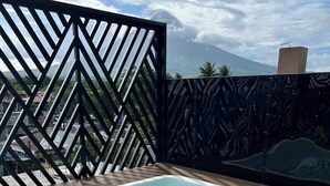 A swimming pool with a geometric fence, clear blue water, and a mountain view.