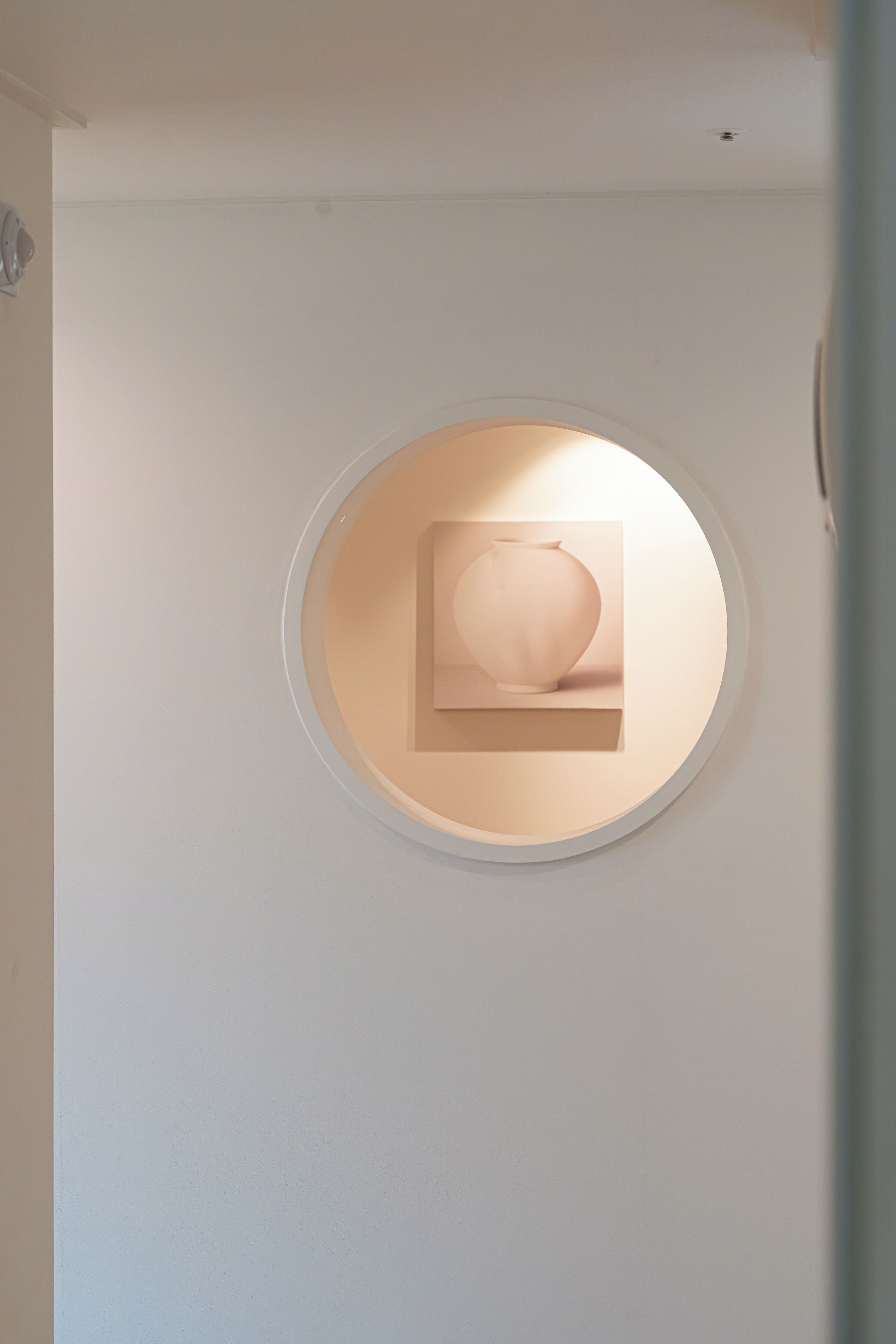 A circular recessed wall feature with a square object inside.