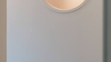 A circular recessed wall feature with a square object inside.