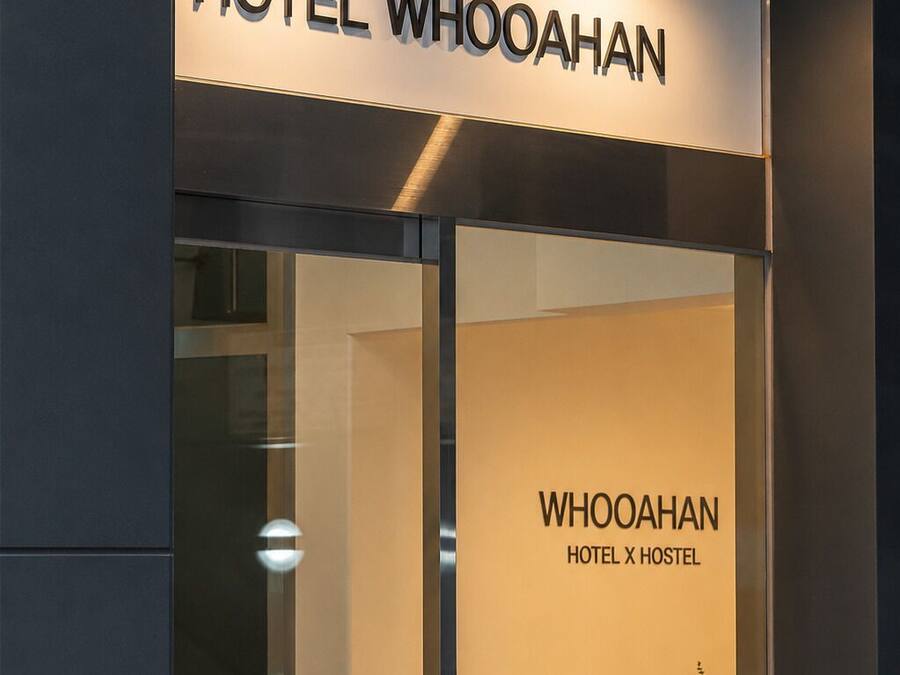 L'ingresso di un hotel con un cartello che recita 'HOTEL WHOOAHAN' e 'WHOOAHAN HOTEL HOSTEL'.