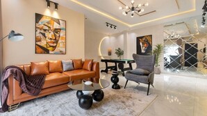 Una sala moderna con sofá, sillón, mesa de centro y obras de arte.