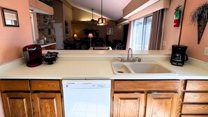 A kitchen with a dishwasher, a coffee maker, and a sink. - Los Indios sits on a secluded cove on Lake Thunderbird (Cherokee Village)