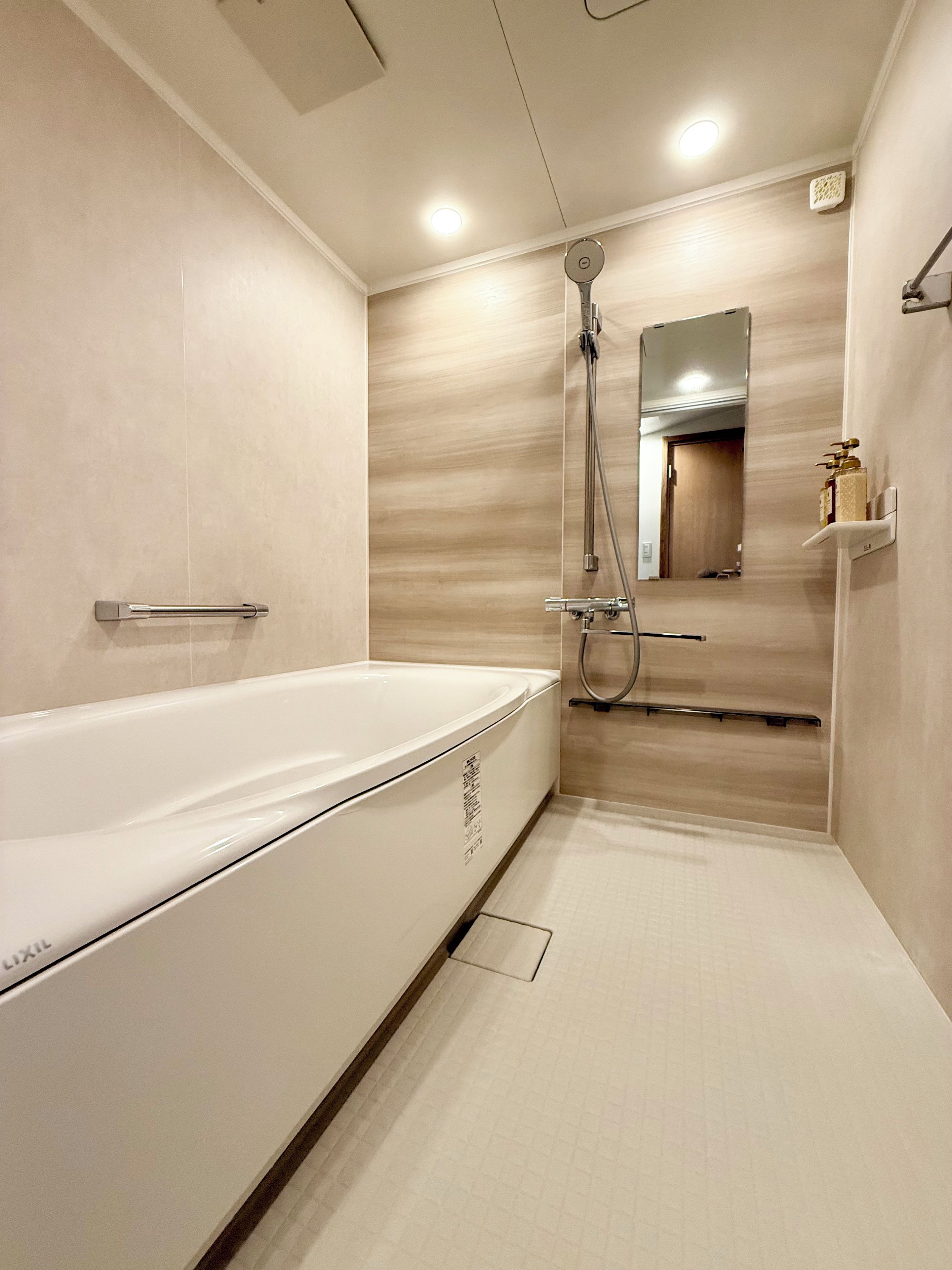 A modern bathroom with a bathtub, a shower, and a mirror.