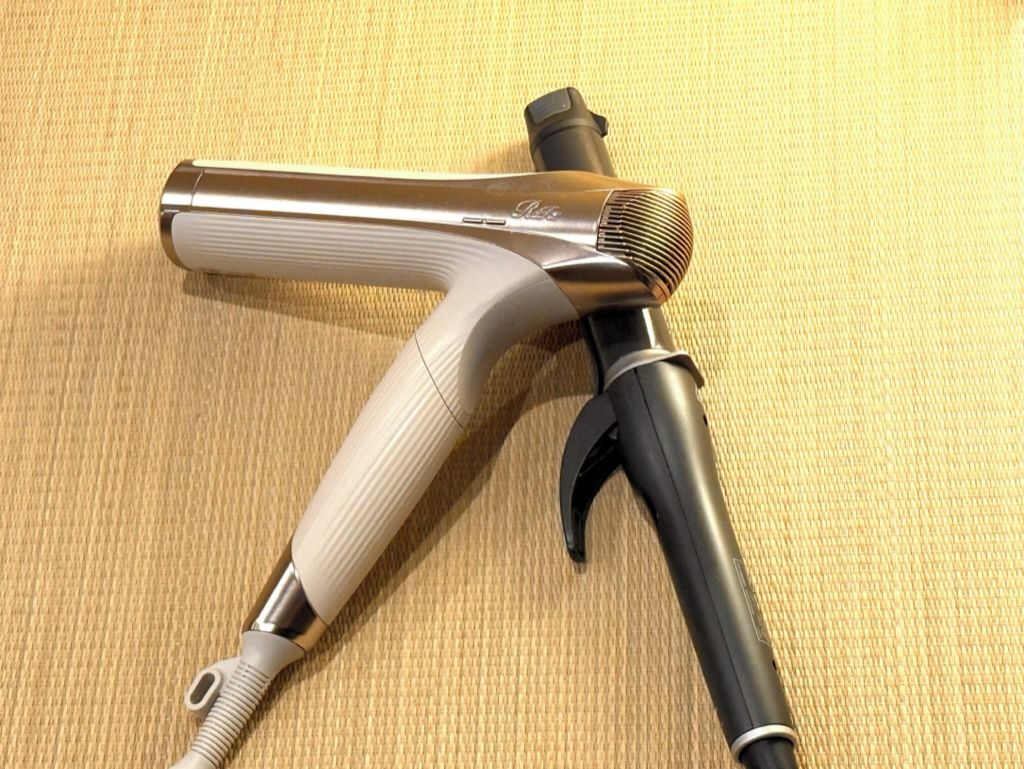 A hairdryer with a metallic body and a wooden handle.
