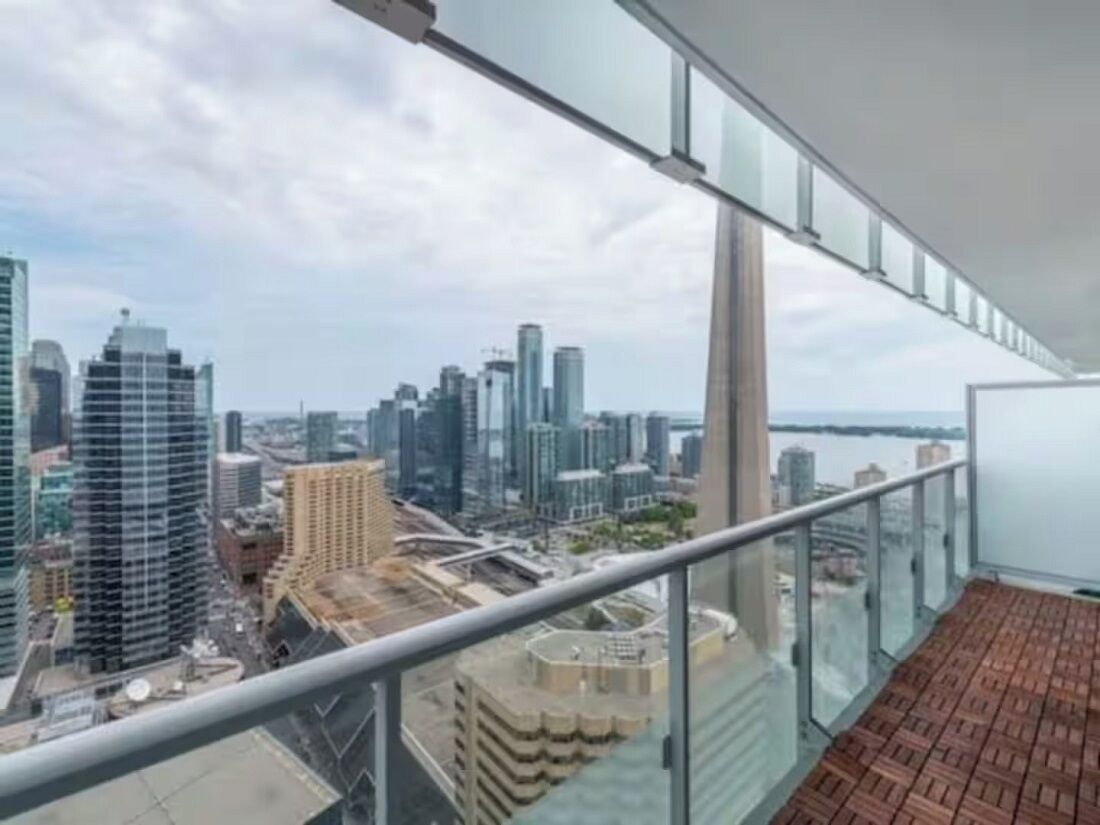 A high-rise building with a glass balcony overlooking a cityscape.