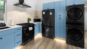 Una cocina moderna con estufa, horno, microondas, refrigerador y lavadora.